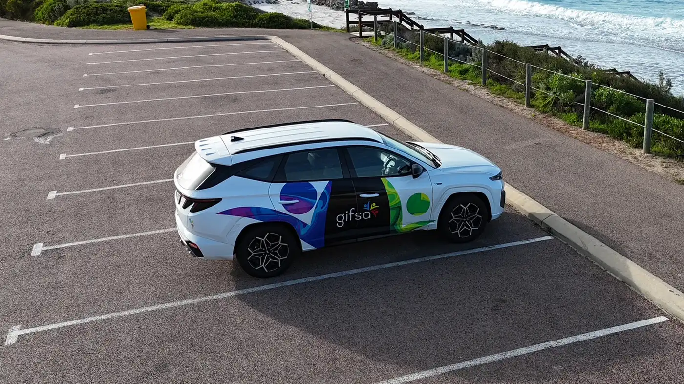 A GIFSA-branded car parked by the coast, seen from above