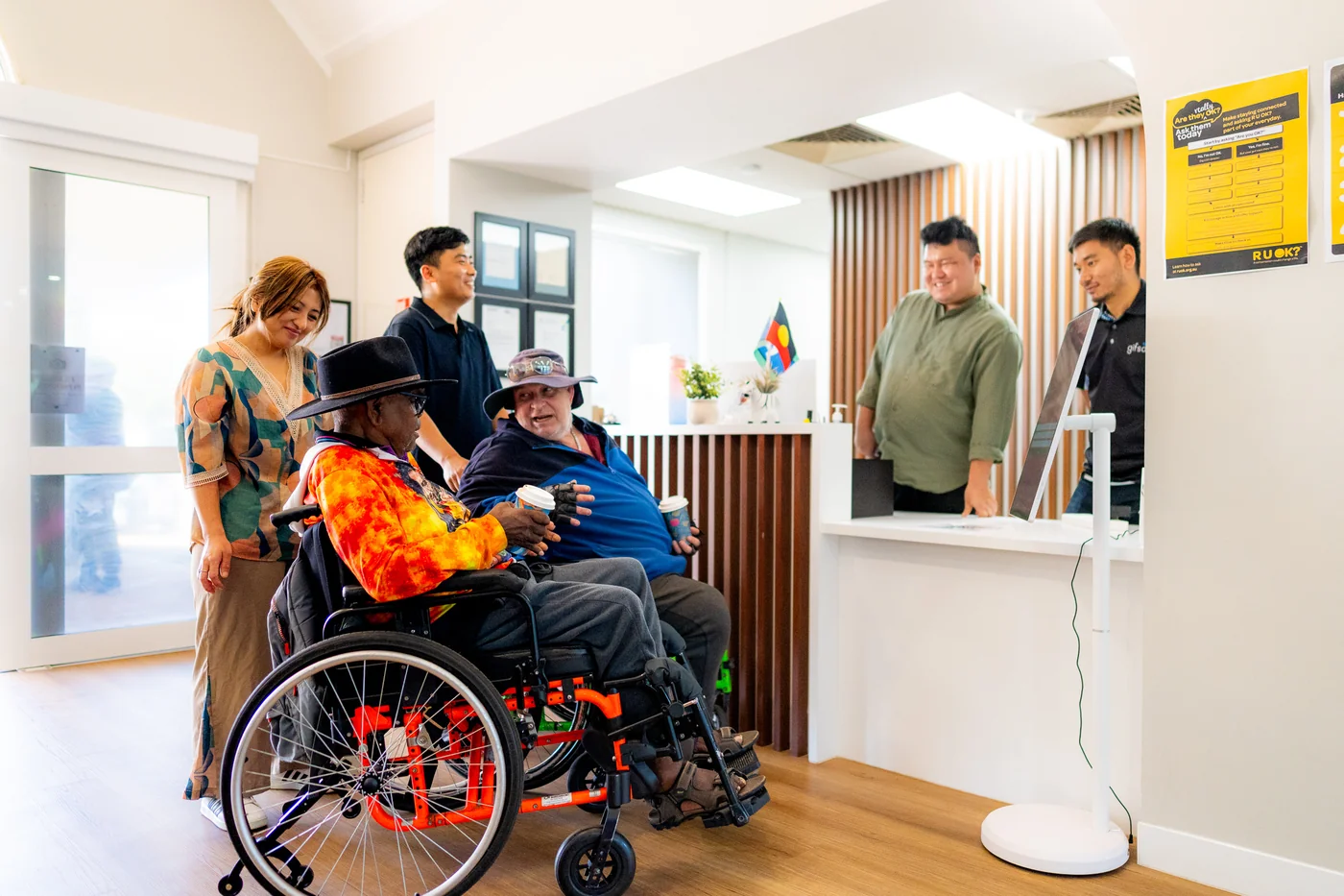 GIFSA staff welcoming participants in wheelchairs at the front desk
