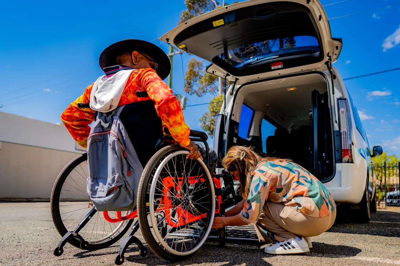 A support worker securing a participant's wheelchair inside a GIFSA accessible van