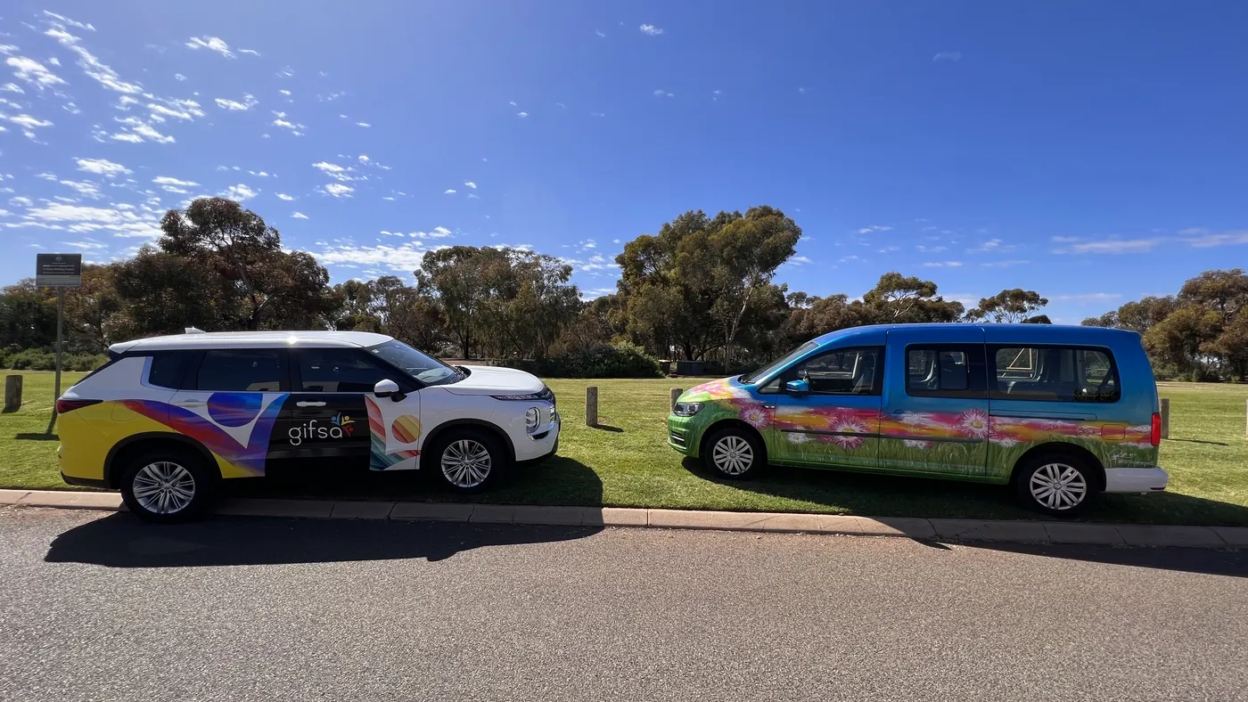 Two GIFSA vehicles with colourful artwork parked on grass