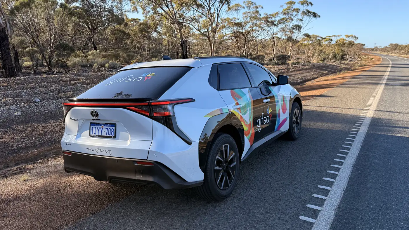 A GIFSA-branded electric car on an outback road lined with bush